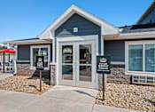 Thumbnail 31 of 74 - a blue house with two signs in front of it at Red Rock Apartments, Rapid City, 57702