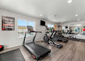 Thumbnail 45 of 74 - two treadmills and other exercise equipment in a gym with windows at Red Rock Apartments, Rapid City