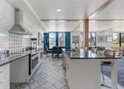 Thumbnail 12 of 35 - a kitchen with an island and a dining room with a table and chairs at City View St. George Apartments, Utah