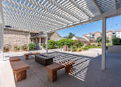 Thumbnail 6 of 35 - a covered patio with benches and a fire pit at City View St. George Apartments, Utah, 84770
