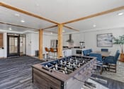 Thumbnail 15 of 35 - a family room with a foosball table and a kitchen with a dining area at City View St. George Apartments, St George
