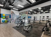 Thumbnail 16 of 35 - a gym with treadmills and other exercise equipment and a mural on the wall at City View St. George Apartments, St George, UT