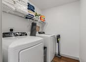 Thumbnail 35 of 35 - a washer and dryer in a small laundry room with white walls and wood at City View St. George Apartments, St George, Utah