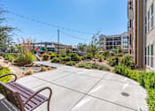Thumbnail 7 of 35 - an outdoor patio with benches and plants in a building with other buildings at City View St. George Apartments, St George, UT, 84770