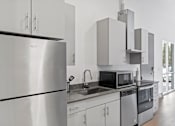 Thumbnail 79 of 131 - A modern kitchen with stainless steel appliances and white cabinets.