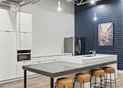 Thumbnail 10 of 55 - A modern kitchen with white cabinets and a grey countertop.