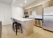 Thumbnail 27 of 34 - a kitchen with a white counter top and a stainless steel refrigerator