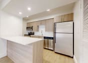 Thumbnail 22 of 34 - a kitchen with a white counter top and a stainless steel refrigerator