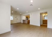 Thumbnail 26 of 34 - an empty living room and kitchen with white walls and wood floors