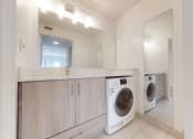 Thumbnail 31 of 34 - a washer and dryer in a laundry room with a sink and a mirror