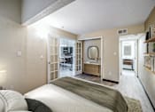 Thumbnail 20 of 51 - A bedroom with a bed, a desk, and a mirror.