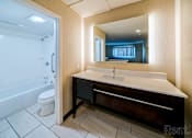 Thumbnail 17 of 17 - A bathroom with a sink, mirror, and bathtub.