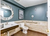 Thumbnail 18 of 45 - A bathroom with a toilet, sink, and mirror.
