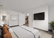 Thumbnail 25 of 92 - A bedroom with a large bed and a flat screen TV mounted on the wall.