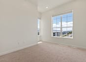Thumbnail 127 of 144 - A large empty room with a window overlooking a cityscape.