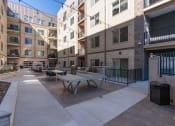 Thumbnail 17 of 84 - a communal patio with tables and chairs in an apartment building at The Revival, Salt Lake City, Utah