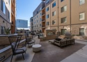 Thumbnail 14 of 84 - a communal patio with furniture and tables in front of an apartment building at The Revival, Utah