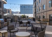 Thumbnail 13 of 84 - a rooftop patio with tables and chairs and a grill at The Revival, Salt Lake City