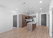 Thumbnail 116 of 144 - A kitchen with wooden floors and a white counter.