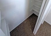 Thumbnail 12 of 14 - A white refrigerator with a metal handle and a white carpeted floor.