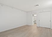 Thumbnail 54 of 61 - an empty living room with white walls and wood flooring at AVIA Lofts on Liberty Ridge, Florida, 32256