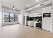 Thumbnail 16 of 55 - A spacious kitchen with white cabinets and stainless steel appliances.