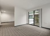 Thumbnail 75 of 92 - A room with a carpeted floor and a sliding glass door. at AVIA Lofts on Parkway Apartments, Vancouver, WA