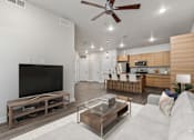 Thumbnail 132 of 136 - A modern living room with a flat screen TV and a kitchen area in the background.