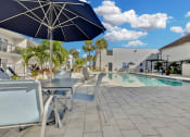 Thumbnail 5 of 41 - a swimming pool with tables and chairs next to a building