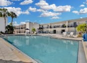 Thumbnail 1 of 41 - a large swimming pool in front of a hotel with palm trees