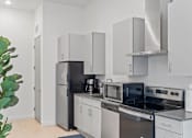Thumbnail 77 of 131 - A modern kitchen with a black refrigerator and stove.