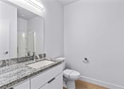 Thumbnail 28 of 55 - A bathroom with a toilet, sink, and mirror.