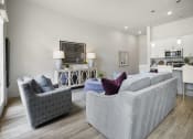 Thumbnail 51 of 83 - a living room with two couches and two chairs and a kitchen in the background at 200 City View, Provo, 84601