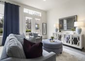 Thumbnail 58 of 83 - a living room with a gray couch and a gray ottoman at 200 City View, Provo