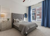 Thumbnail 81 of 83 - a bedroom with a bed and a window with blue curtains at 200 City View, Provo, UT