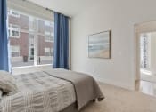 Thumbnail 80 of 83 - a bedroom with a bed and a large window with blue curtains at 200 City View, Utah