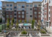 Thumbnail 10 of 83 - an apartment building with a pool and bikes parked in front of it at 200 City View, Provo, UT, 84601