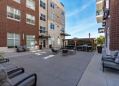 Thumbnail 17 of 83 - an outside patio with tables and chairs and a brick building at 200 City View, Provo, Utah