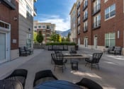 Thumbnail 20 of 83 - an outdoor patio with tables and chairs and a fire pit at 200 City View, Provo, UT
