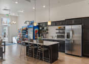 Thumbnail 39 of 83 - a kitchen with stainless steel appliances and a bar with three stools at 200 City View, Provo