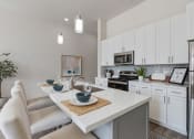Thumbnail 68 of 83 - an open kitchen and dining area with white cabinets and stainless steel appliances at 200 City View, Provo, UT, 84601