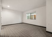 Thumbnail 76 of 92 - A room with a carpeted floor and a window with blinds. at AVIA Lofts on Parkway Apartments, Vancouver, 98662