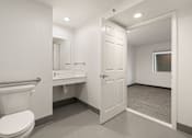 Thumbnail 85 of 92 - A white toilet is in a small bathroom with a white sink and a white door at AVIA Lofts on Parkway Apartments, Vancouver, WA, 98662