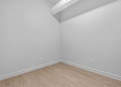 Thumbnail 39 of 55 - A room with a light wooden floor and white walls.
