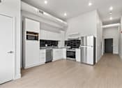 Thumbnail 35 of 55 - A modern kitchen with white cabinets and stainless steel appliances.