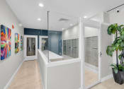 Thumbnail 16 of 41 - a long white room with a large mirror and a plant