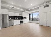 Thumbnail 29 of 55 - A modern kitchen with stainless steel appliances and white cabinetry.