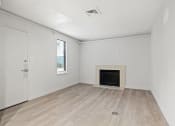 Thumbnail 56 of 61 - an empty living room with a fireplace and wooden floors at AVIA Lofts on Liberty Ridge, Jacksonville, FL, 32256