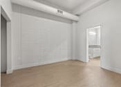 Thumbnail 31 of 55 - A white room with a brick wall and wooden floor.