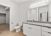 Thumbnail 26 of 55 - A bathroom with a toilet, sink, and mirror.